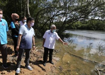 HASSAN Abdul Karim (kanan) menunjukkan keadaan air Sungai Kim-Kim di Tanjung Langsat, Pasir Gudang, Johor. - UTUSAN/BAAZLAN IBRAHIM