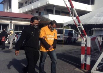 TIMBALAN Pengarah JPJ Perlis di bawa keluar dari mahkamah selepas mendapatkan perintah reman selepas dipercayai terlibat dalam sindiket melindungi pemandu-pemandu lori di Mahkamah Majistret, Kangar, Perlis hari ini.- UTUSAN/NAZLINA NADZARI