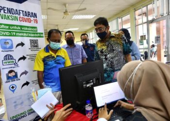 ZAHIDI (kanan) beramah mesra dengan penduduk yang mendaftar pengambilan vaksin semasa Program Jelajah Malaysia Prihatin di Dewan Kemas Alor Tampang, Beseri, Perlis hari ini.- UTUSAN/NAZLINA NADZARI