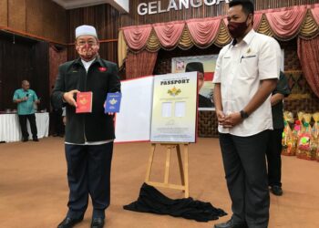 MD. Anizam Ab. Rahman (kiri) memunjukkan pasport pada majlis pelancaran Pasport Muzium di Gelanggang Seni, Kota Bharu. - UTUSAN/ROSLIZA MOHAMED