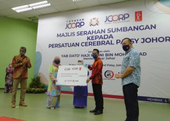 ZAITON Ismail (tengah) menyaksikan Rozaini Mohd. Sani (dua kanan) menyampaikan replika cek kepada Pengerusi Persatuan Cerebral Palsy Johor, Tunku Fatimah Faridah Tunku Osman di Johor Bahru, Johor. -UTUSAN/ KHAIRUL MOHD ALI