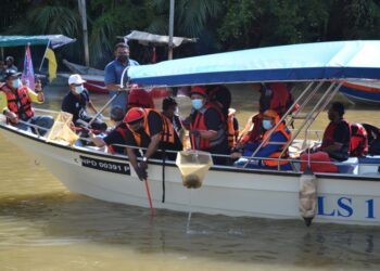 AMINUDDIN Harun turut sama mengutip sampah di Sungai Linggi sempena Majlis Perasmian Hari Air Sedunia Peringkat Negeri Sembilan di Pengkalan Kempas, Port Dickson hari ini.-UTUSAN/ZAKKINA WATI AHMAD TARMIZI.