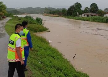 ANGGOTA APM memantau paras air Sungai Linggi di Kuala Sawah, Rantau dekat sini petang tadi.