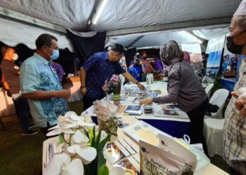 MOHD. Sharkar Shamsudin (tengah, baju biru tua) dan Sh. Mohmed Puzi Sh. Ali (kiri) meninjau gerai ejen pelancongan di perkarangan Menara 188 Kuantan di Kuantan, Pahang semalam.