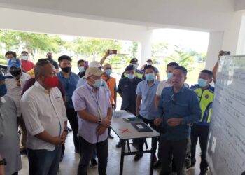 BUNG Moktar Radin (dua dari kiri) diiringi Menteri Pelancongan, Kebudayaan dan Alam Sekitar Sabah, Datuk Jafri Ariffin (kiri) mendengar taklimat ringkas mengenai mangsa kebakaran Kampung Simunul yang ditempatkan di PPR Bubul Ria. - UTUSAN/SURAIDAH ROSLAN