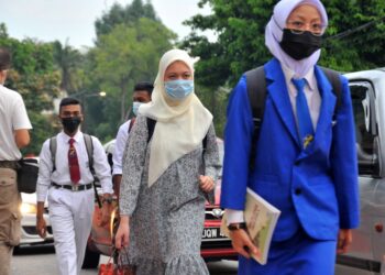 PARA PELAJAR sekolah memakai pelitup muka ketika memasuki perkarangan sekolah pada hari pertama sesi persekolahan 2021 dibuka semula di SMK Aminuddin Baki, Johor. -UTUSAN/RAJA JAAFAR ALI