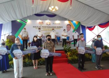 HASNI Mohammad (belakang, tengah) bergambar bersama sebahagian penerima kunci RMMJ Bandar Cemerlang, di Ulu Tiram, Johor. -UTUSAN/KHAIRUL MOHD ALI