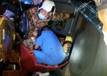 ANGGOTA bomba menyelamatkan mangsa yang cedera setelah bas dinaiki terbabas dan terbalik di Kilometer 265, Lebuh Raya Utara-Selatan arah selatan di Ipoh hari ini. IHSAN JBPM