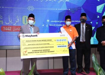 TOSRIN Jarvanthi (kiri) menerima replika cek sumbangan warga Felda Wilayah Segamat di Hotel Holiday Villa, Johor Bahru, Johor.