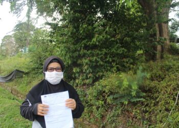 SEORANG penduduk, NORMADIAH Kassim menunjukkan surat aduan yang dibuat kepada PBT yang memohon sebatang pokok sena berusia lebih 30 tahun yang dibimbangi boleh mengundang bahaya kepada penduduk di Rumah Rakyat Kampung Sri Lalang ketika ditemui Utusan Malaysia baru-baru ini.-UTUSAN/NOR AINNA HAMZAH