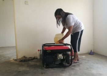 S. V. Letchumi mengisi minyak diesel ke dalam mesin generator miliknya sebagai alternatif untuk menyalurkan bekalan elektrik ke rumahnya di sebuah flat di Taman Desa Kempas, Johor. -UTUSAN/MOHAMAD FAIZAL HASHIM