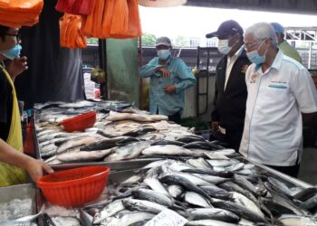 HASSAN Abdul Karim (kanan) melihat jualan ikan semasa mengadakan lawatan ke Pasar KIP Mart Masai, di Pasir Gudang, Johor. -UTUSAN/KHAIRUL MOHD ALI