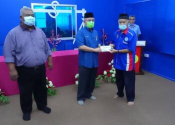 DR. Adham Baba (tengah) menyerahkan peruntukan kepada salah sebuah NGO pada Majlis Penyampaian Peruntukan Parlimen Tenggara di Pusat Khidmat Wakil Rakyat Ahli Parlimen Tenggara, Taman Daiman di Kota Tinggi, Johor. -UTUSAN/MASTURAH SURADI