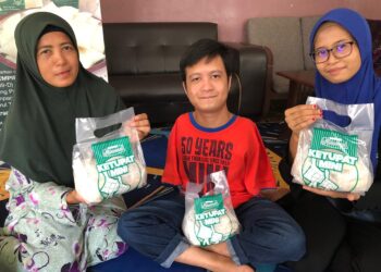MUHAMAD Safar (tengah) mengusahakan perniagaan Ketupat Mini Muhammad bersama Nor Azlia (kanan) dan Hattyca Karmon di Kampung Parit Haji Hashim, Simpang Renggam, Kluang di Johor. -UTUSAN/NUR NABILAH RAHMAT