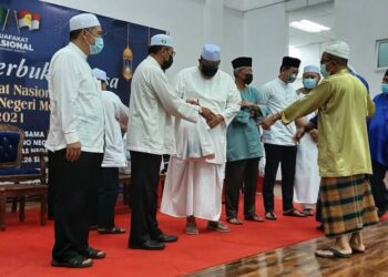 AB. RAUF Yusoh (tiga dari kiri) dan Kamaruddin Sidek (dua dari kiri) menyampaikan sumbangan kepada cawangan-cawangan UMNO di Serkam pada majlis berbuka puasa MN di Japerun Serkam, Jasin, Melaka. - UTUSAN/AMRAN MULUP