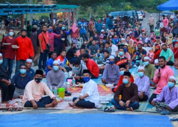 JALALUDDIN Alias (depan tengah) tidak ketinggalan bersama penduduk Taman Perumahan Generasi Baru Felda (PGBF) Anggerik 2 Felda Pasoh 1, Jelebu berbuka puasa di atas jalan raya di hadapan rumah penduduk. - UTUSAN/MUHAMMAD IZZAT TERMIZIE