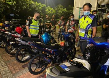 DZULKHAIRI Mukhtar (kanan) melihat motosikal yang disita kerana kesalahan ubah suai dalam operasi khas di sekitar Iskandar Puteri, Johor.