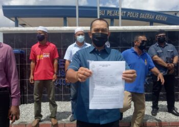 ABDUL Yunus Jamahri menunjukkan laporan polis terhadap sebuah portal berita di IPD Kerian di Bagan Serai. - UTUSAN/WAT KAMAL ABAS