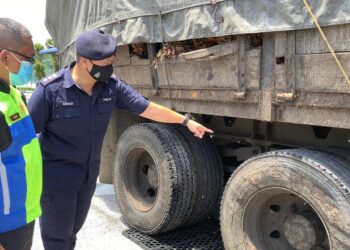 AHMAD Adnan Basri (kanan) menunjukkan keadaan lori muatan sawit yang uzur dan tayar botak pada pemeriksaan timbang berat kenderaan itu di IPD Hilir Perak di Teluk Intan.