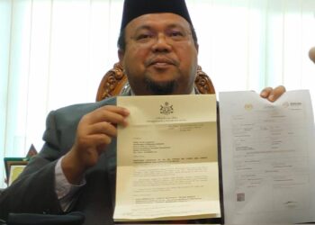 ABDULLAH Ya’kub menunjukkan notis pemakluman kekosongan kerusi DUN Melor yang akan diserahkan kepada SPR di Kota Darul Naim, Kelantan. - UTUSAN/YATIMIN ABDULLAH