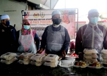 SYED Abu Hussin Al Hafiz Syed Abdul Fasal (dua dari kanan) mengedarkan bungkusan nasi beriani di Pusat Khidmat Parlimen Bukit Gantang. -  UTUSAN/WAT KAMAL ABAS