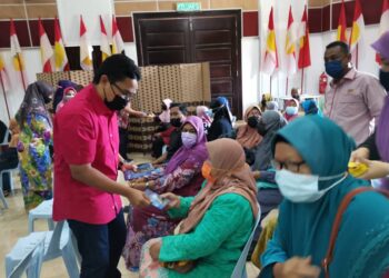 KHAIRUL Azwan Harun menyampaikan sumbangan raya kepada kepada asnaf di Pasir Salak. - UTUSAN/AIN SAFRE BIDIN