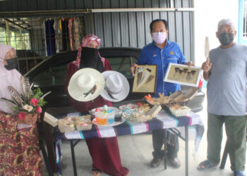 AHMAD Maslan (dua dari kanan) bersama pengusaha menunjukkan produk hiliran daripada ternakan ayam Belanda ketika mengadakan lawatan di Parit Haji Zain Laut, Api-Api di Pontian, Johor. - UTUSAN/MUHAMMAD ZIKRI
