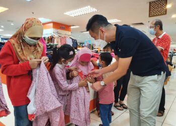 OH Tong Keong membantu kanak-kanak daripada Persatuan Anak Yatim Balik Pulau memilih pakaian baharu dalam program pembelian kelengkapan Aidilfitri anjuran Parti Gerakan Pulau Pinang.