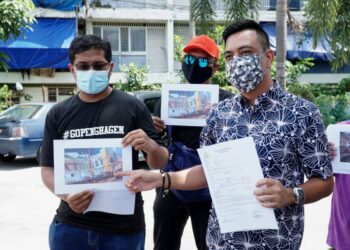 AL Yashir Yahaya (kanan) menunjukkan gambar bendera negeri Perak separuh tiang dan laporan polis yang dibuat di Balai Polis Kampung Rapat, Ipoh. -  UTUSAN/ZULFACHRI ZULKIFLI