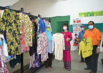 NICOLE Tan Lee Koon menunjukkan pakaian baharu dan terpakai yang tersedia untuk diberikan secara percuma sempena Aidilfitri ketika ditemui pemberita pada Program Muhibah Raya di Taman Bukit Kepayang, Seremban. - UTUSANZAKKINA WATI AHMAD TARMIZI