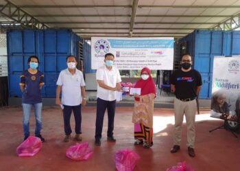 MOHD. Ali Mohd. Salleh (tengah) menyampaikan sumbangan kepada penerima sempena program Majlis Sumbangan Hari Raya Aidilfitri 2021 di Kampung Melayu Majidee, Johor. - UTUSAN/KHAIRUL MOHD. ALI