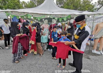 BEBERAPA orang anak Khalis mencuba baju raya yang ditaja oleh Iman Boutique di Dataran Senawang, Seremban. - UTUSAN/AFIFI HAFIZ MOHD. NOR
