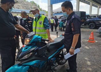 HASAN BASRI Yahya (kanan) dan penguat kuasa JAS (tengah) memeriksa salah sebuah motosikal yang dirampas dalam operasi Jumaat lalu. - UTUSAN/DIYANATUL ATIQAH ZAKARYA
