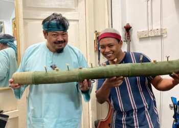 MUDZAFAR Irfan (kanan) menunjukkan panjut buluh yang dihasilkan disamping pengarah terkenal, Mamat Khalid di Ipoh baru-baru ini.