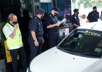 MIOR Faridalathrash Wahid (tiga dari kiri) memeriksa dokumen pemandu kereta di SJR Plaza Tol Ipoh Utara di Ipoh. - UTUSAN/ZULFACHRI ZULKIFLI