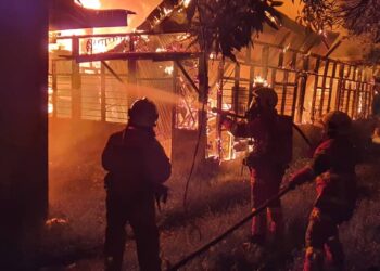 ANGGOTA bomba memadam kebakaran rumah setinggan di Padang Tembak di Teluk Intan. - UTUSAN/IHSAN JBPM