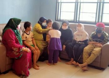 NORADILAH Rani (tiga dari kiri) bersama anak-anaknya ketika menerima kunjungan Pertubuhan Kebajikan Ehsan Penyayang Johor Bahru di rumahnya di Pangsapuri Desa Hajah Hasnah di Johor. -UTUSAN/KHAIRUL MOHD ALI