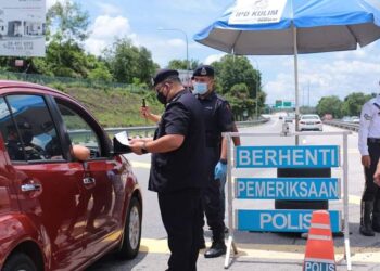 AZHAR Hashim memeriksa surat kebenaran merentas negeri daripada seorang pemandu di SJR Plaza Tol Lebuh Raya BKE, Lunas, Kulim, hari ini. - UTUSAN/AZAHAR HASHIM