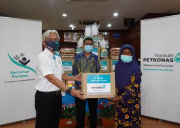 SAZLI Zakaria (kiri) menyerahkan barangan bantuan kepada Jemilah Said (kanan) sambil disaksikan Pengarah JKM Negeri Melaka, Burhanuddin Bachik pada sesi penyerahan barangan bantuan Sentuhan Kasih Aidilfitri di Melaka. - UTUSAN/MUHAMMAD SHAHIZAM TAZALI