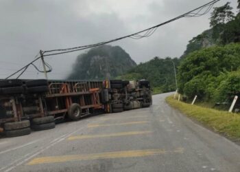 KEADAAN lori kontena terbalik di Kilometer 3, Jalan Gua Musang-Kuala Krai, Gua Musang, Kelantan. - UTUSAN/AIMUNI TUAN LAH