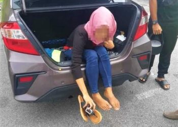 WANITA warga Indonesia yang cuba bersembunyi dalam bonet kereta ditahan pihak polis dalam SJR Plaza Tol Simpang Ampat, Melaka. - UTUSAN/DIYANATUL ATIQAH ZAKARYA