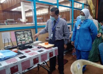 DR. MOHD. Azman Yacob menunjukkan rakaman pengawasan menerusi CCTV yang dilakukan petugas di setiap PKRC di Kelantan ketika melawat PKRC Gelanggang Seni, Kota Bharu. - UTUSAN/ROHANA MOHD. NAWI