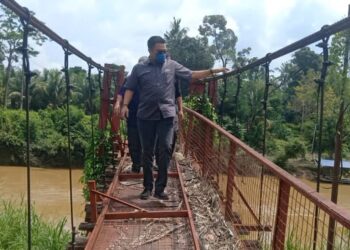 MOHD. Sharkar Shamsudin (depan) meninjau kerosakan jambatan Gantung Mambang Berulang di Mentakab, Temerloh, Pahang. - UTUSAN/SALEHUDIN MAT RASAD