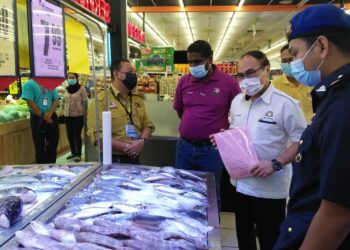 CHONG Fat Full (dua dari kanan) memantau hasil laut yang merupakan antara barangan yang dikawal SHMMP dalam Program Walkabout SHMMP Hari Raya Peringkat Negeri Johor di Segamat, Johor. -UTUSAN/FARAHWAHIDA AHMAD