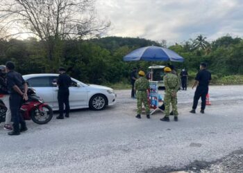 PETUGAS barisan hadapan membuat pemeriksaan kenderaan di sekatan jalan raya (SJR) di kilometer 98, jalan Lipis-Merapoh berdekatan Merapoh di Lipis, Pahang sejak PKP 12 Mei lalu. - UTUSAN/HARIS FADILAH AHMAD