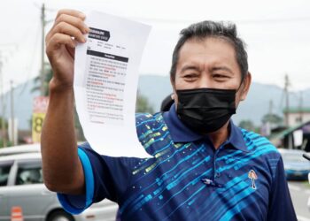 JAAFAR Uthman menunjukkan laporan polis yang dibuat mengenai berita palsu kononnya pasar malam ditutup sepanjang PKP di Balai Polis Manjoi, Ipoh. - UTUSAN/ZULFACHRI ZULKIFLI