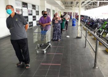 PELANGGAN berbaris membeli barang keperluan ketika tinjauan di sebuah pusat beli-belah di Ipoh. - UTUSAN/ZULFACHRI ZULKIFLI