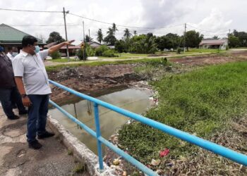 MOHAMAD Ali Mohamad menunjukkan Sungai Ayer Salak  yang dipenuhi semak samun dan kiambang di Kampung Bukit Datuk A, Bukit Rambai, Melaka. - UTUSAN/AMRAN MULUP