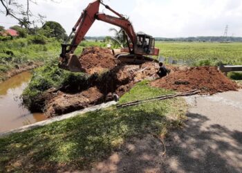 KERJA-KERJA membaiki ban yang pecah sedang giat dilakukan oleh JPS di Paya Luboh, Tangga Batu, Melaka. - UTUSAN/AMRAN MULUP