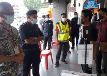 ADZLI Abu Shah (dua kiri) berbual bersama peniaga ketika membuat pemantauan dan penguatkuasaan SOP PKP 3.0 di Sungai Petani.